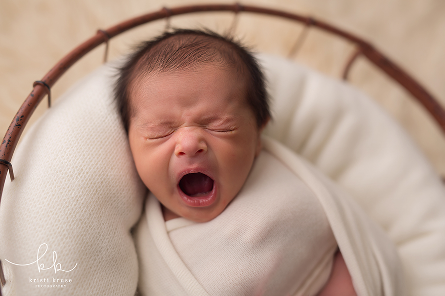 Baby boy in basket yawning