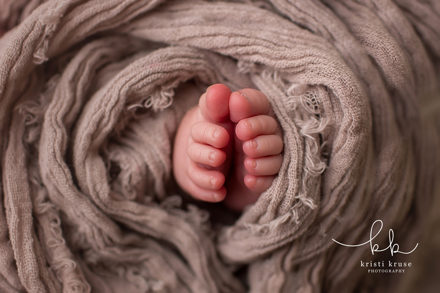 baby toes wrapped in brown swaddle