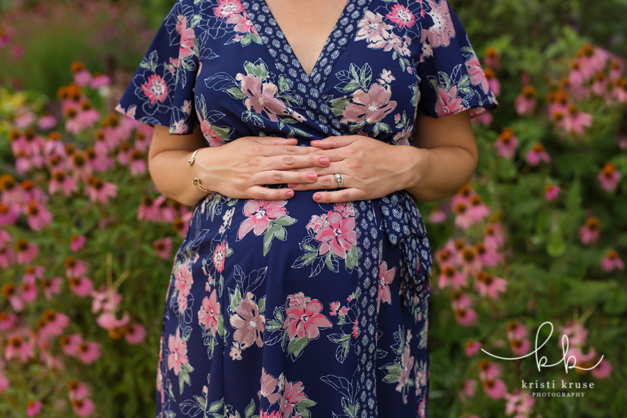 Expectant mother in floral dress with hands on top her belly